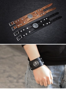 Macro shot of retro wide leather punk bracelet with metallic rivets and skull cross badge