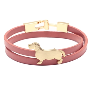 Pulsera de cuero de doble capa con dije de perro salchicha dorado en fondo blanco