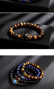 Détail de bracelets en perles avec œil de tigre, pierre de lave et breloques couronnes