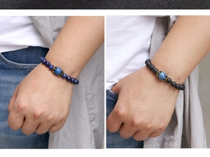Détail de bracelets en œil de tigre bleu et pierre de lave noire avec accents couronne