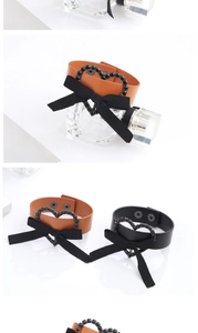 Détail de bracelets en cuir PU avec cœur en strass et nœud noir, montrant le bouton pression