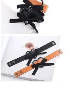 Détail de bracelets en cuir PU avec nœuds papillon et boucles strass cœur en noir et orange
