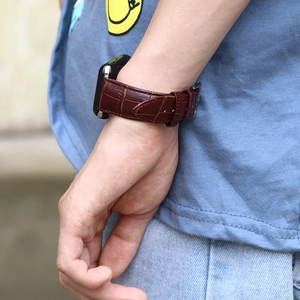 Dark brown crocodile leather strap for Apple Watch with silver buckle shown on wrist
