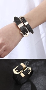 Detail of black snake pattern PU leather bracelet with double golden geometric buckles