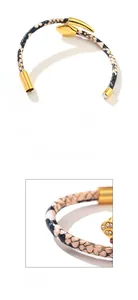 Macro detail of gold snake head charm with pavé crystals and snake print leather strap