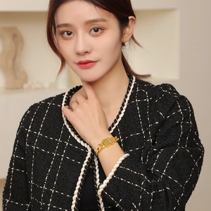 Bracelet élégant à gros maillons dorés avec boucle carrée sur le poignet d'un mannequin