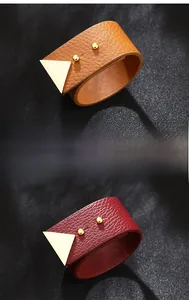 Close-up of litchi texture leather bracelets with golden triangle studs and rivets