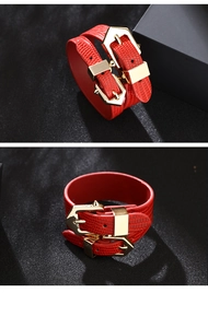 Close-up of red lizard pattern leather bracelet with golden double buckle and studs