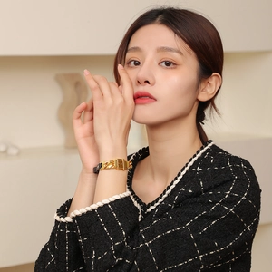 Bracelet élégant en cuir PU avec chaîne et boucle dorées porté par un mannequin femme