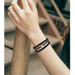 Close-up of triple-layer leather bracelet featuring gold star charm and leopard print detail