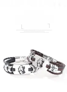 Dettaglio della piastra in metallo con leopardo su bracciali in pelle intrecciata