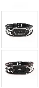 Detail of woven leather bracelets with God Bless metal plate and cross charm detail