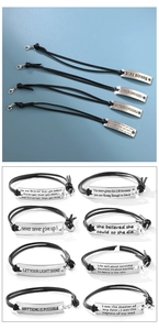 Close-up of leather bracelets with motivational quotes on curved metal plates