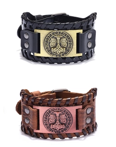 Close-up of leather Viking bracelets with Mjolnir metal plate and braided edges