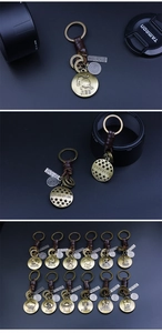 Gros plan d'un porte-clés zodiaque vintage en bronze avec cordon en cuir tressé et médailles