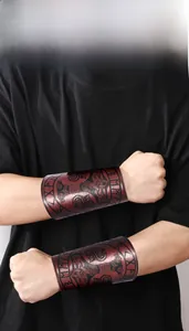 Close-up of brown leather wristband featuring embossed Mjolnir and Norse rune patterns