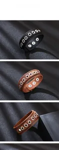 Detailed view of punk leather bracelets with metal eyelets in black and brown tones