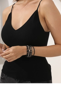 Detail of bohemian multilayer black leather wrap bracelet with golden heart charms