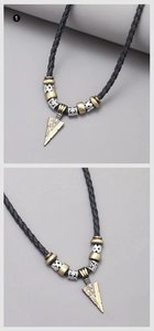 Détail macro du pendentif flèche rétro avec gravures métalliques et cordon en cuir