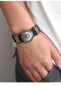 Detail eines geflochtenen Lederarmbands mit Türkis und griechischer Mäander-Schnalle