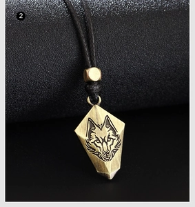 Vue macro du pendentif tête de loup vintage avec bouclier géométrique sur cordon noir