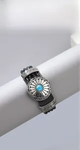 Detail eines Lederarmbands mit blauem Türkis und silberner Sonnenstrahl-Verzierung
