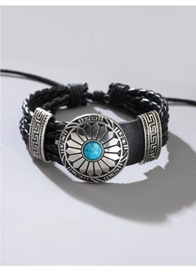 Makroaufnahme des geflochtenen Lederarmbandes mit gravierter Sonne und blauer Türkisperle