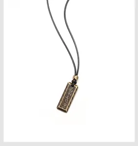 Détail du pendentif rectangulaire en bronze vintage avec gravures de runes nordiques