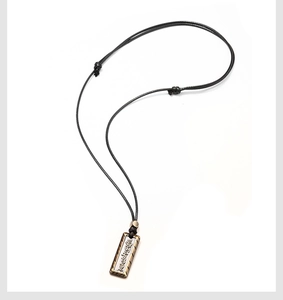Vue détaillée du pendentif loup vintage avec caractères gravés sur un cordon de cire noir