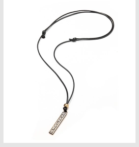 Détail du pendentif loup vintage avec gravures sacrées sur cordon noir tressé