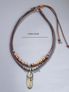 Detail of vintage ethnic necklace with bronze feathers, wood beads and adjustable cord