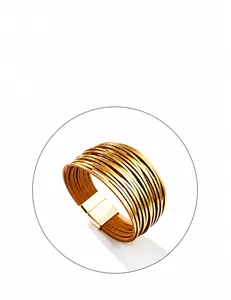 Detail van meerlagige leren wikkelarmband met gouden accenten en magneetsluiting