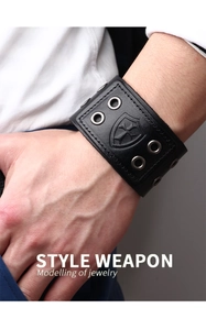 Detail view of mens black leather bracelet with silver cross shield and rivet accents