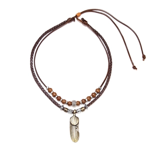 Vintage bohemian layered necklace with woven leather cord and metal feather pendant