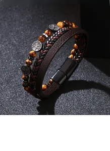 Detail of multi-layer leather bracelet featuring tiger eye beads and tree of life charm