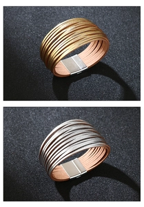 Detail van gelaagde gevlochten lederen armbanden met magnetische metalen sluitingen