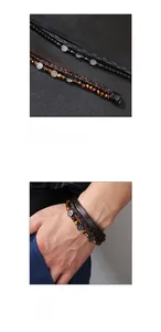 Detail of multi-layer braided leather bracelet with tiger eye stone and tree of life charm