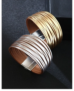Detail van meerlaagse wikkelarmbanden met magnetische metalen sluiting in goud en zilver