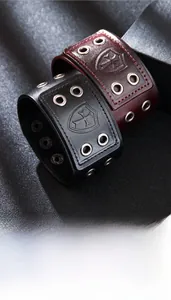 Detail of vintage leather bracelets with embossed shield cross and metal eyelets