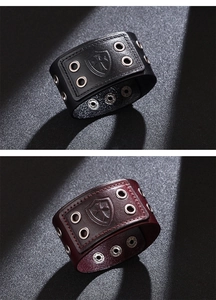 Close-up of vintage leather bracelets with embossed shield cross and metallic eyelets