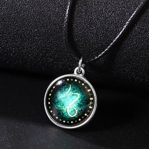 Luminous Capricorn constellation necklace with green nebula glass pendant on black cord