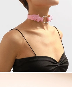 Close-up of pink leather choker with silver ring and bat wings on model neck