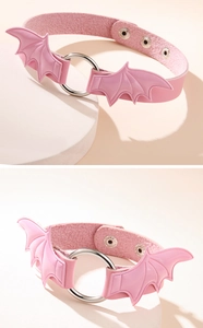 Pink gothic choker featuring pastel bat wings and adjustable metal buckle closure detail