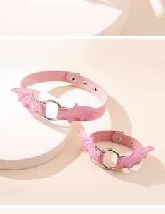 Detail view of pink leather choker with metal ring and 3D bat wings on a stand