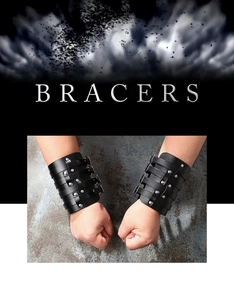Detail of black leather bracers with silver metal rivets and adjustable buckle straps