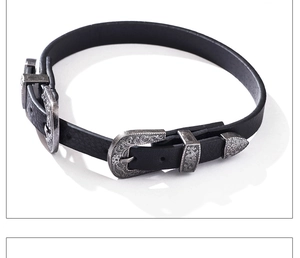Détail d'un ras-du-cou en cuir noir avec trois boucles métalliques gravées de style vintage