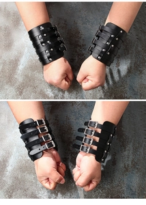 Close-up of black leather bracers with four adjustable silver metal buckles and rivets