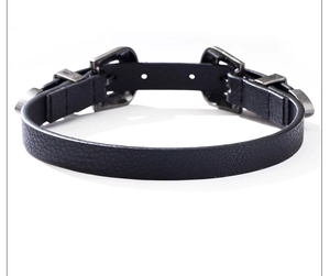 Détail de la boucle en métal sculpté rétro sur un collier ras du cou en cuir noir