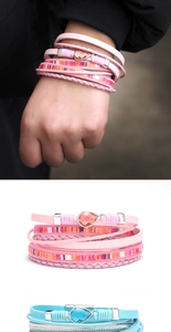 Detail of bohemian multilayer wrap bracelets with teardrop gems in pink and blue