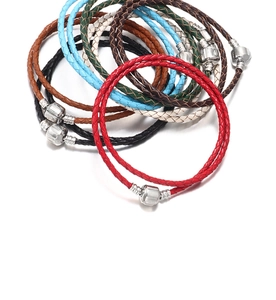 Macro detail of braided leather bracelets with silver metal clasps in multiple colors